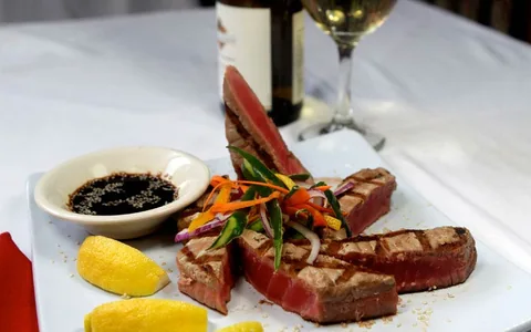Steak served with vegetables and sauce.
